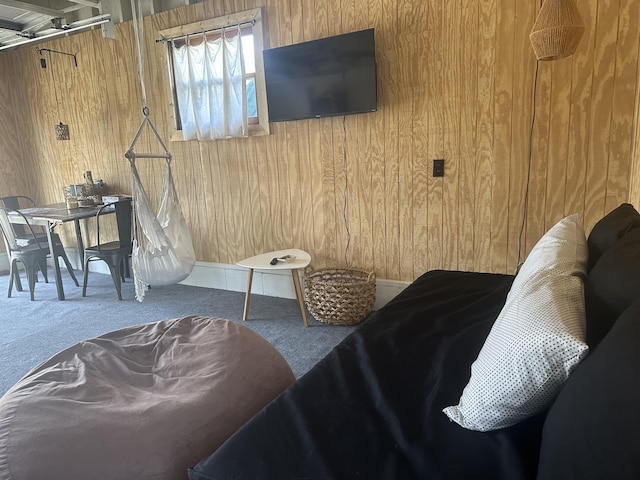 carpeted bedroom featuring wood walls