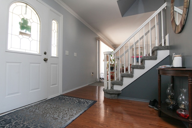 foyer entrance with crown molding, stairway, wood finished floors, and baseboards