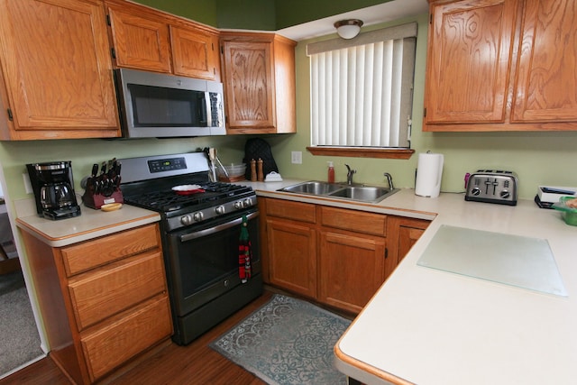 kitchen with a sink, light countertops, brown cabinets, and stainless steel appliances