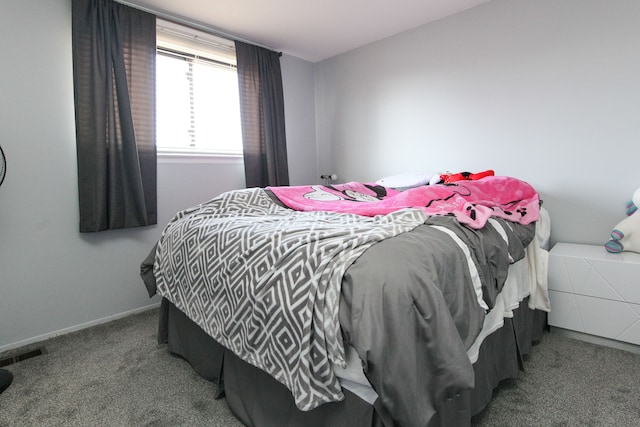 carpeted bedroom featuring baseboards and visible vents