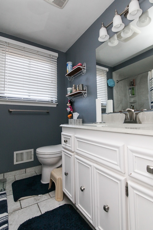 full bath with a wealth of natural light, visible vents, toilet, and vanity