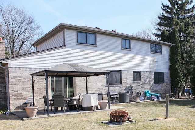 back of property featuring a patio, cooling unit, an outdoor fire pit, a gazebo, and a lawn