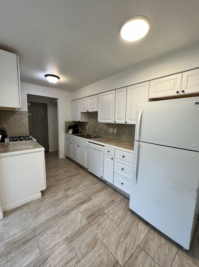 kitchen featuring white cabinetry, white appliances, and a sink