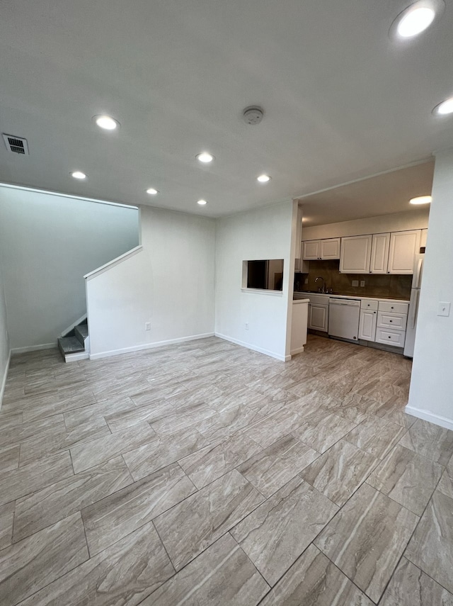 unfurnished living room with recessed lighting, visible vents, and baseboards