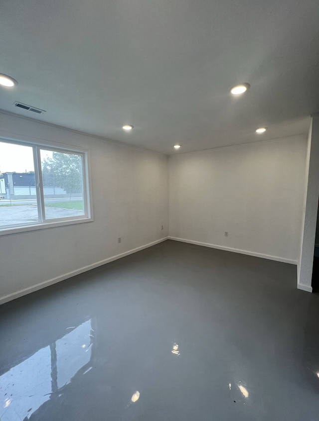 unfurnished room with visible vents, recessed lighting, concrete flooring, and baseboards