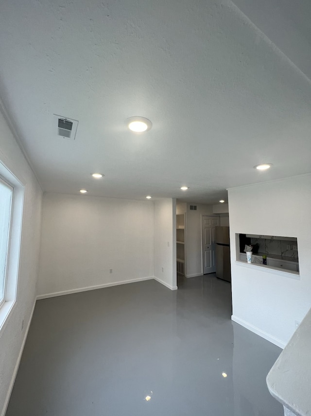 unfurnished living room featuring recessed lighting, visible vents, baseboards, and concrete flooring