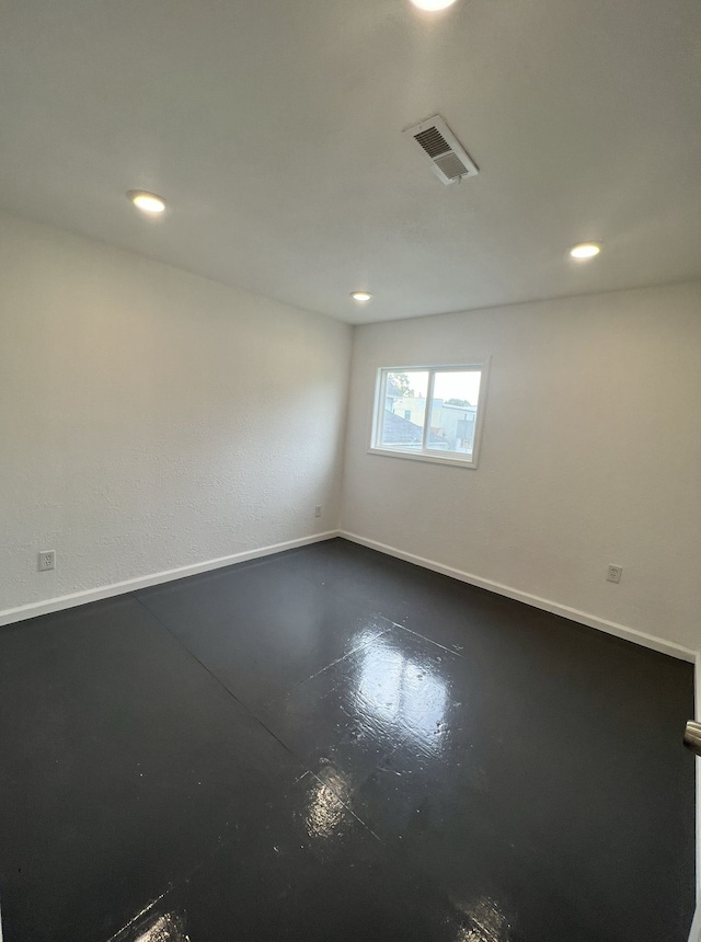 empty room with visible vents, recessed lighting, concrete flooring, and baseboards