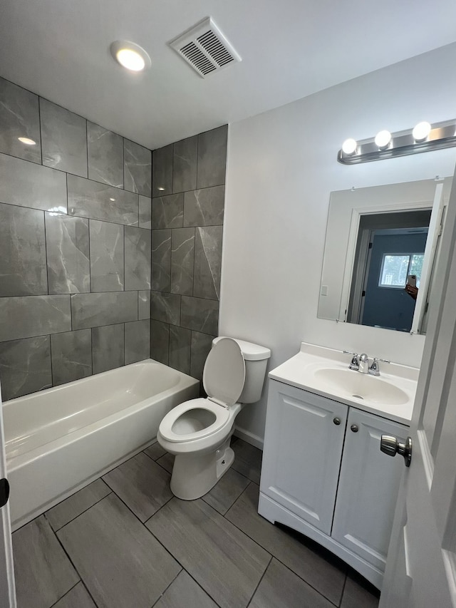 bathroom featuring visible vents, baseboards, toilet, bathtub / shower combination, and vanity