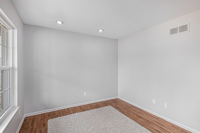 unfurnished room featuring dark wood finished floors, recessed lighting, baseboards, and visible vents