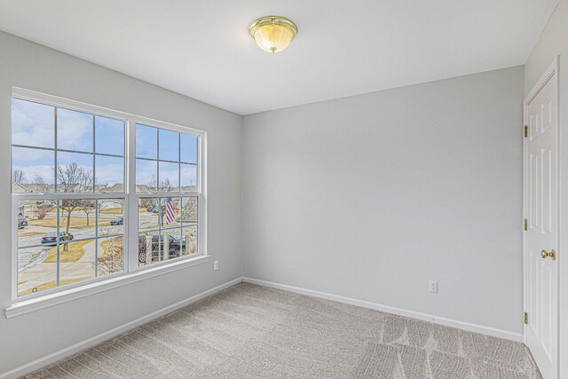 unfurnished room with baseboards and carpet