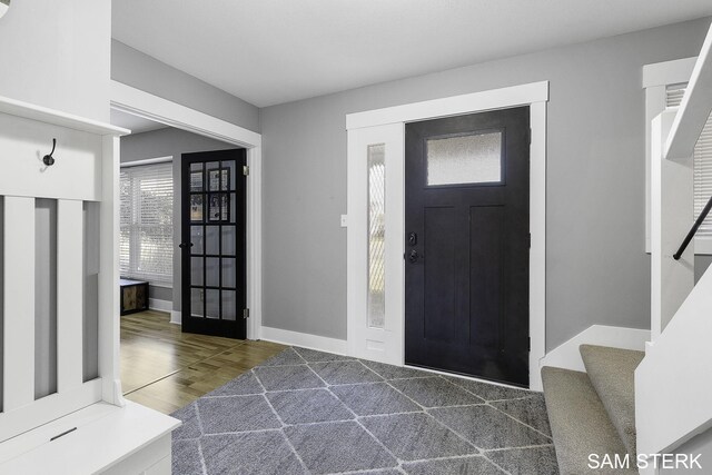 entrance foyer with stairway, baseboards, and wood finished floors