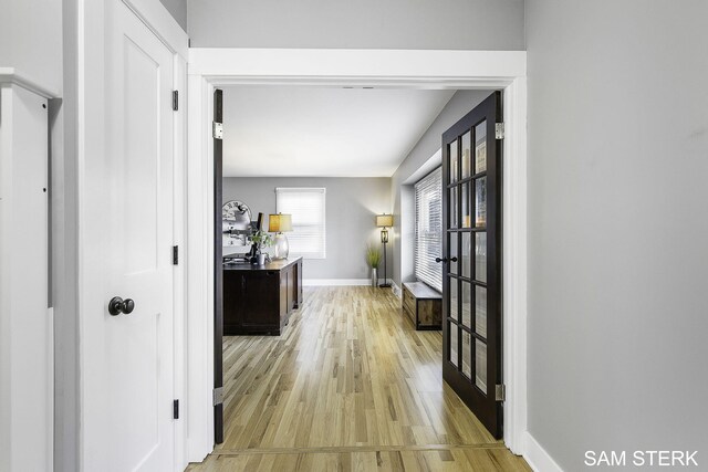 hallway with baseboards and light wood finished floors