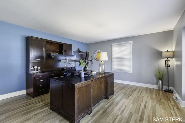 office area with visible vents, baseboards, and light wood finished floors