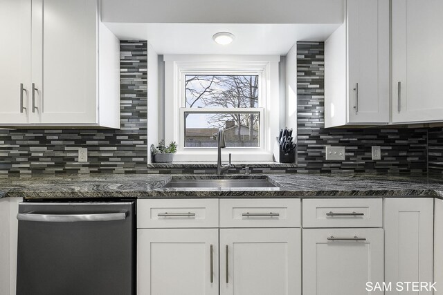 kitchen with a sink, dishwashing machine, tasteful backsplash, and white cabinetry