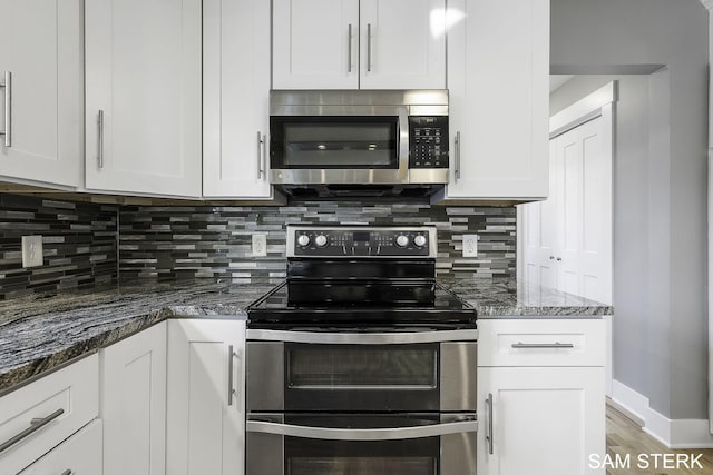 kitchen featuring backsplash, baseboards, stone counters, appliances with stainless steel finishes, and white cabinets