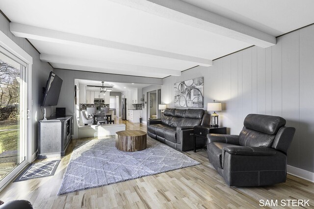 living area with beamed ceiling and light wood finished floors