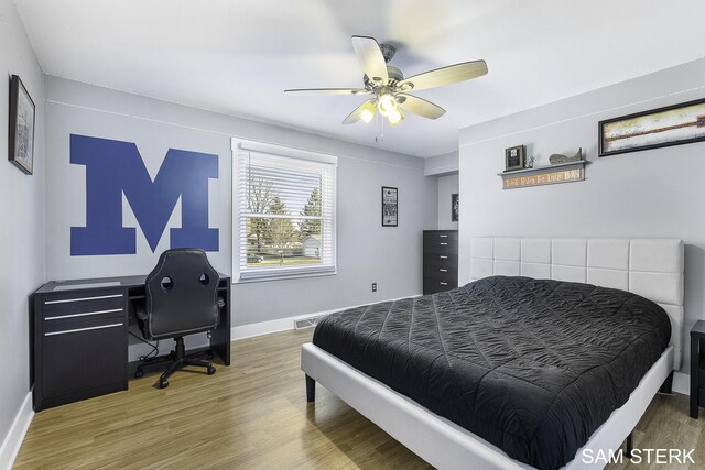 bedroom with baseboards, wood finished floors, and a ceiling fan