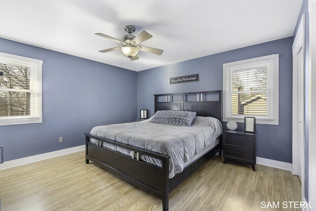 bedroom with wood finished floors, baseboards, and ceiling fan