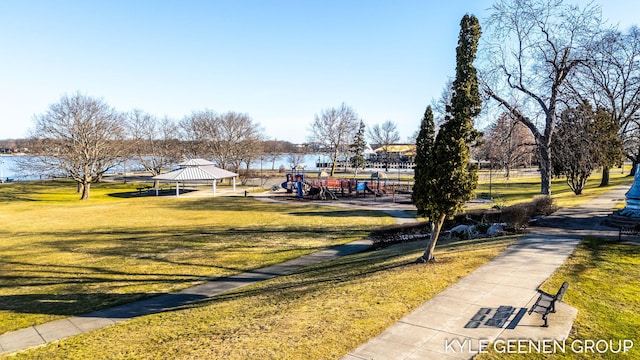 surrounding community with a gazebo, a water view, and a lawn