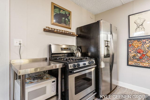 kitchen with white microwave, baseboards, light wood finished floors, a drop ceiling, and stainless steel gas stove