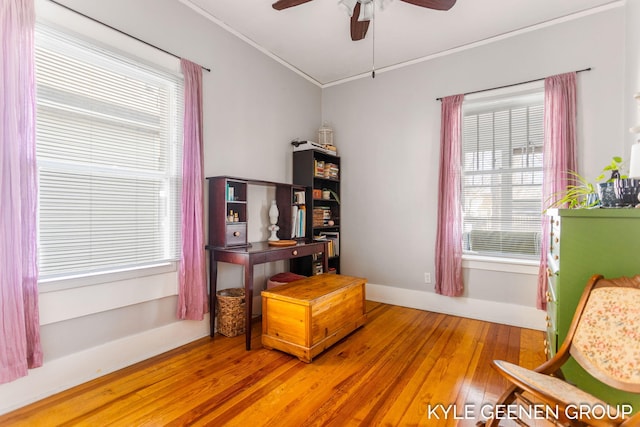 sitting room featuring baseboards, crown molding, ceiling fan, and wood-type flooring