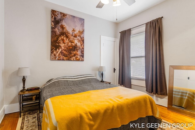 bedroom featuring a ceiling fan, baseboards, and wood finished floors