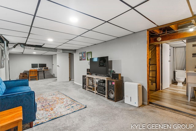 carpeted living room featuring a drop ceiling