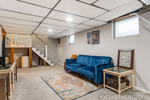 living room with a paneled ceiling, baseboards, carpet floors, and stairs