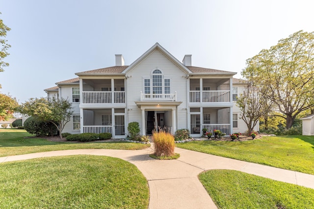 view of front of home featuring a chimney and a front lawn