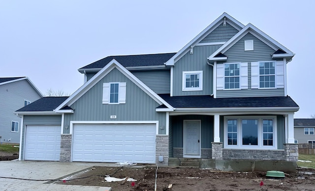 craftsman house with stone siding, covered porch, board and batten siding, and roof with shingles