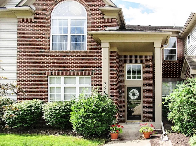 entrance to property featuring brick siding