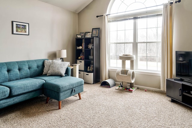 living area featuring lofted ceiling, carpet, and baseboards