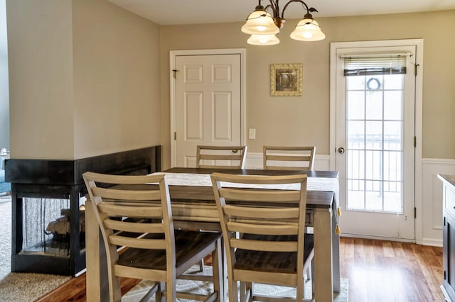 dining space with a wealth of natural light, a chandelier, and wood finished floors