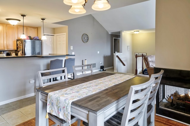 dining space featuring light tile patterned flooring and baseboards