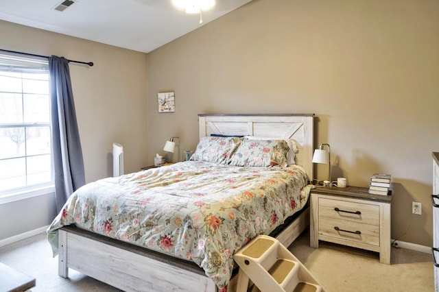 bedroom with visible vents, light carpet, and baseboards