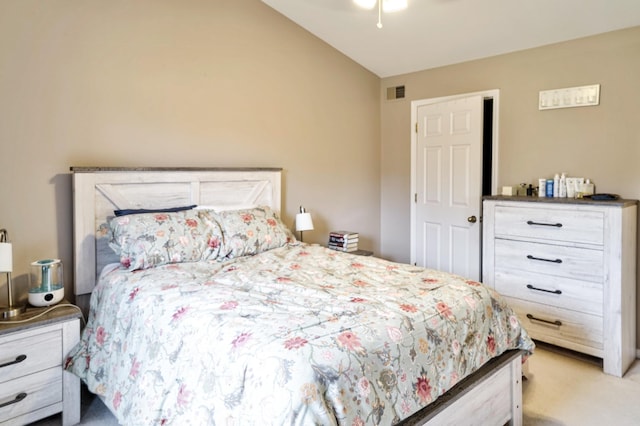 carpeted bedroom featuring vaulted ceiling and visible vents