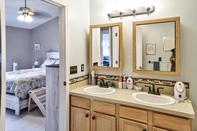 ensuite bathroom with a sink, ensuite bath, double vanity, and ceiling fan