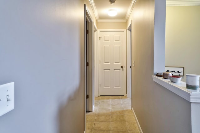 hall featuring light tile patterned flooring, baseboards, and ornamental molding