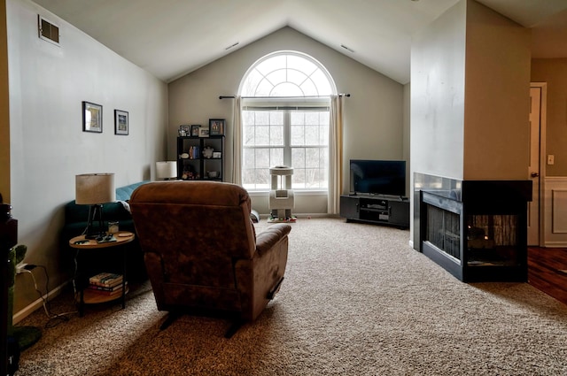 carpeted living area with lofted ceiling, visible vents, and a multi sided fireplace