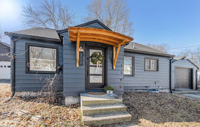 view of front of house featuring a garage and roof with shingles