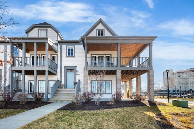 view of front of house with a balcony and a front lawn