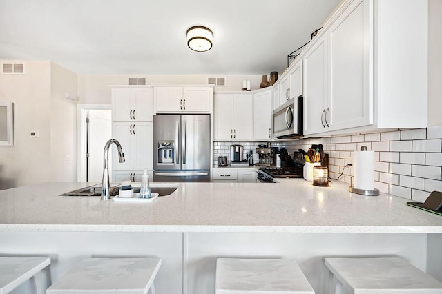 kitchen featuring visible vents, stainless steel appliances, and a sink