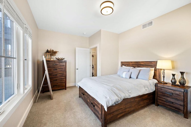 bedroom featuring visible vents, light carpet, and baseboards