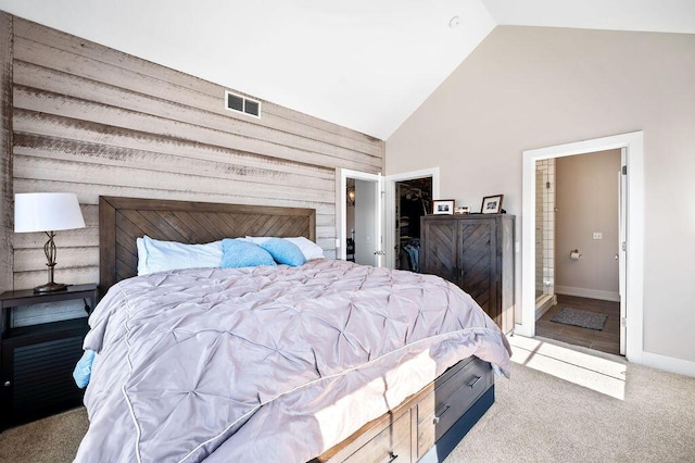 bedroom with carpet, visible vents, baseboards, high vaulted ceiling, and a walk in closet