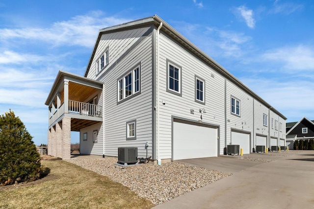 exterior space featuring a balcony, cooling unit, and an attached garage