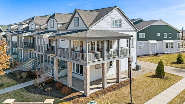 view of front facade featuring a residential view, stairway, roof with shingles, central AC unit, and a patio area