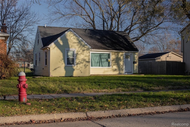 view of front of house with a front lawn and fence