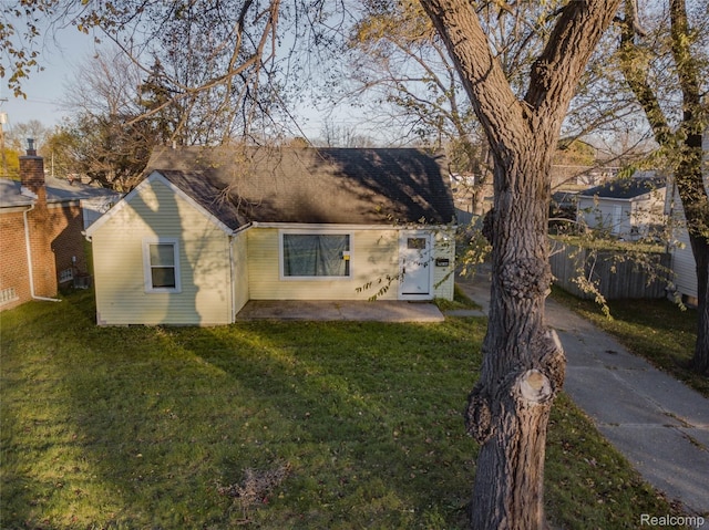 view of front facade featuring a front yard and fence