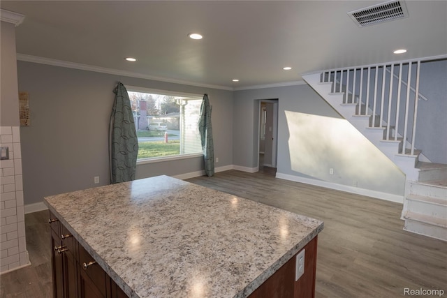 kitchen with crown molding, recessed lighting, wood finished floors, and visible vents