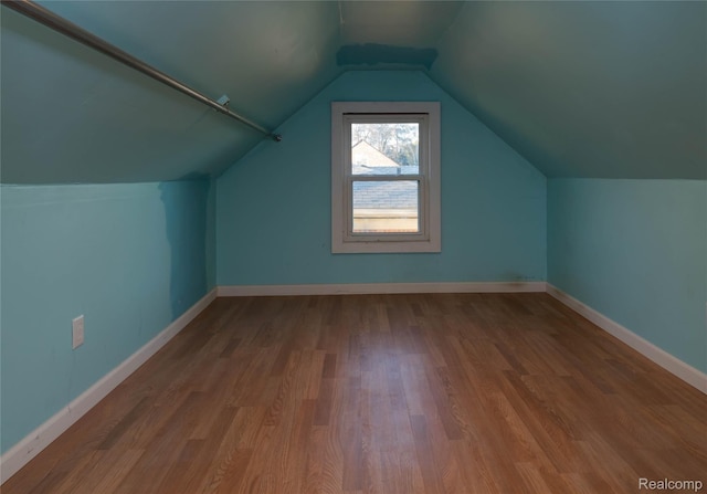 bonus room featuring lofted ceiling, baseboards, and wood finished floors